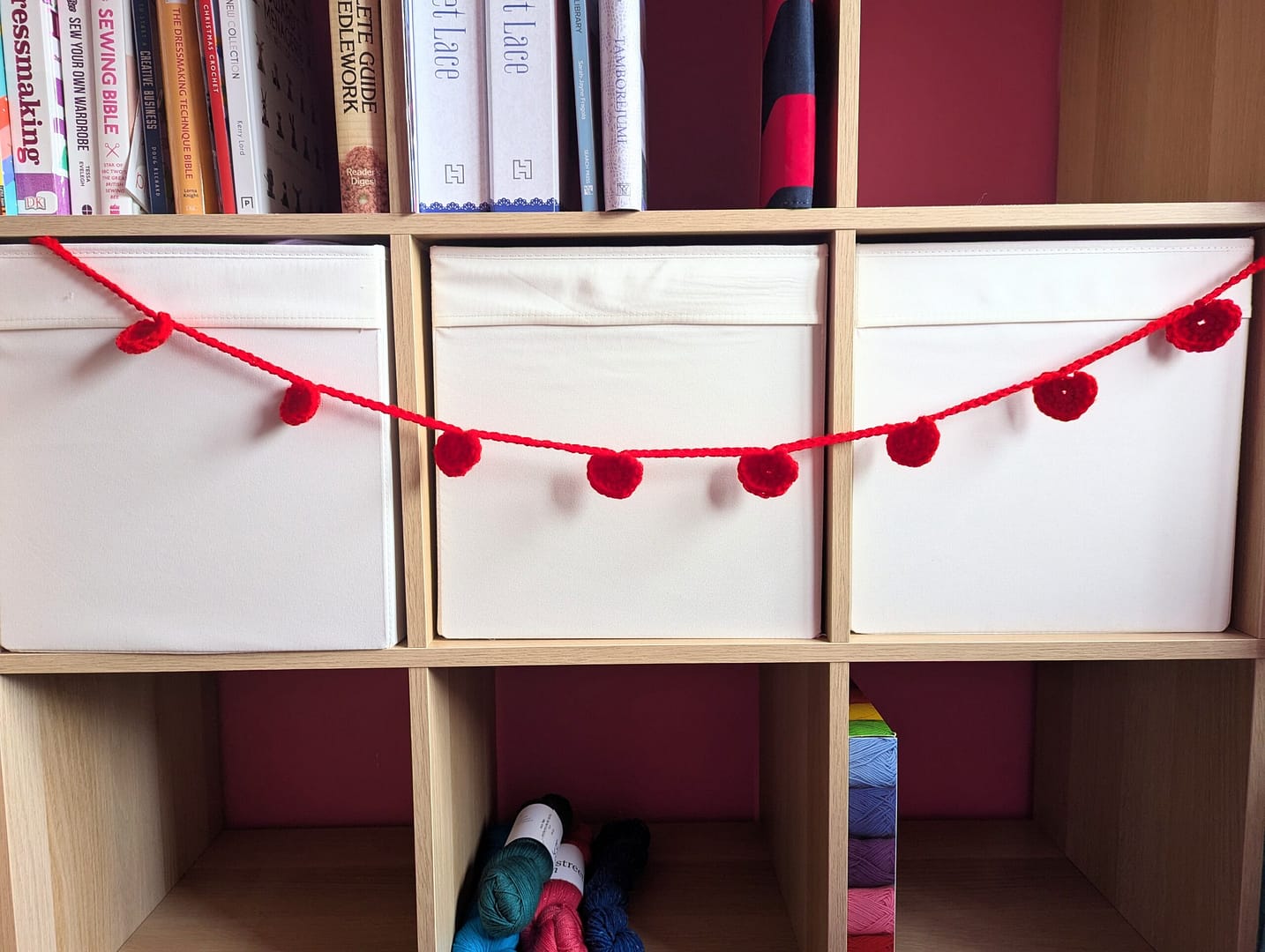 Red crochet heart garland, hung in front of some white boxes