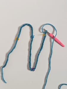 Line of crochet chain stitches in blue yarn