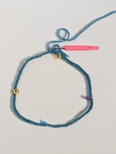 Blue yarn in crochet chain stitches in a circle
