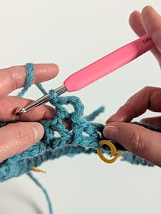 Two hands holding a close up piece of V stitch pattern crochet