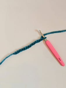 Pink handle crochet hook, and a length of crochet chain stitches