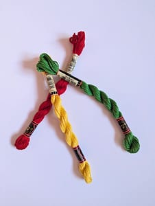 3 skeins of yarn in red, yellow and green