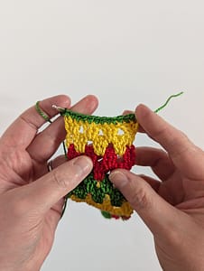 Top line border of single crochet stitches worked in green yarn