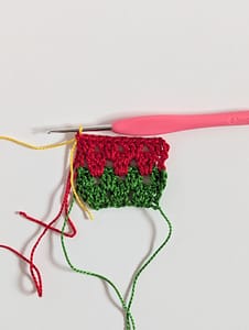 Yellow yarn attached to a row of granny stripe pattern in red yarn