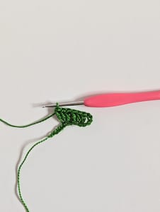 first few stitches of first row of granny stripe crochet pattern in green yarn