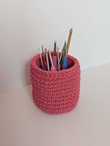 Pink crocheted pot holding crochet hooks