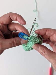 A yarn needle threading yarn through a crochet stitch