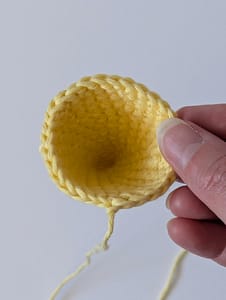 A crochet cone in yellow yarn