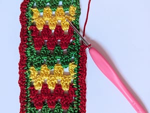 Close up of red yarn border being added to a crochet bookmark