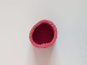 Top view looking down at a pink crocheted pencil pot
